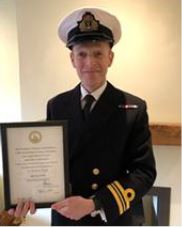 Lt Cdr Simon Cook with his Meritorious Service Certificate