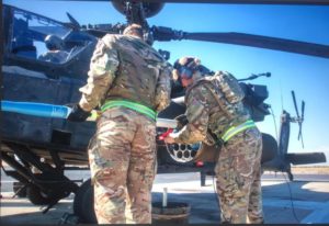 Two reservists load a missile onto an Apache helicopter