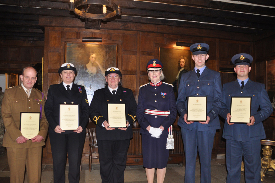 Adult volunteers holding their meritorious service certificates with the Lord lieutenant of essex