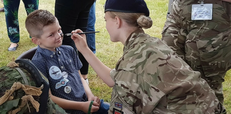 Cadet face-painting a young visitor to the military zone at the Suffolk show