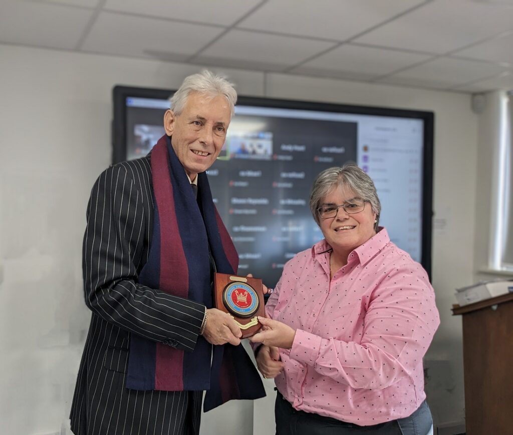 Dr Christopher Bushby receives a plaque in thanks for his contribution to the Reserves and Cadets from East Anglia RFCA Chief Executive Col Leona Barr-Jones