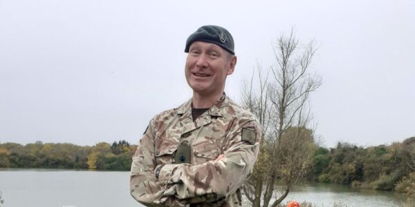 Lt Col Matt Helsby standing in uniform in front of the lake at Coldhams Lane Army Reserve Centre