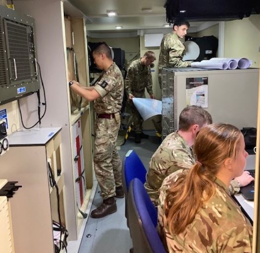 reservists working inside a lorry container fitted out for map printing